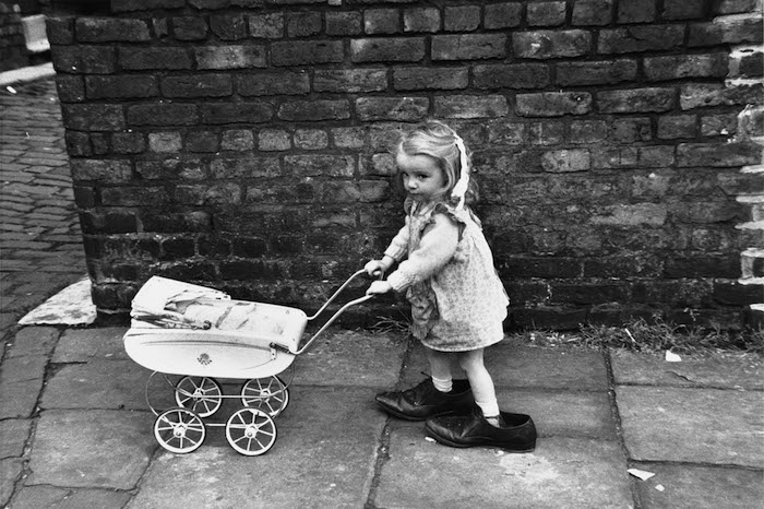 Little girl with toy pram in large shoes - Manchester 1966